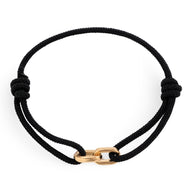 Bracelet cordon noir avec maillons croisés en métal doré, style minimaliste.