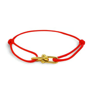 Bracelet cordon rouge avec maillons dorés croisés, fermoir original en métal brillant.