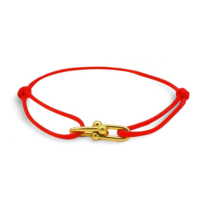 Bracelet cordon rouge avec maillons dorés croisés, fermoir original en métal brillant.