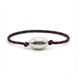 Bracelet cordon noir et rouge avec pendentif en forme de ballon de rugby argenté brillant.