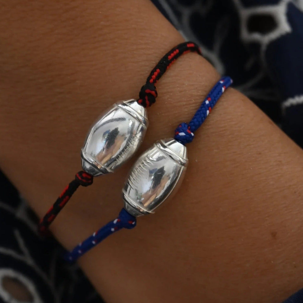 Bracelet cordon bleu et noir avec pendentif ballon de rugby argenté, style sportif masculin.