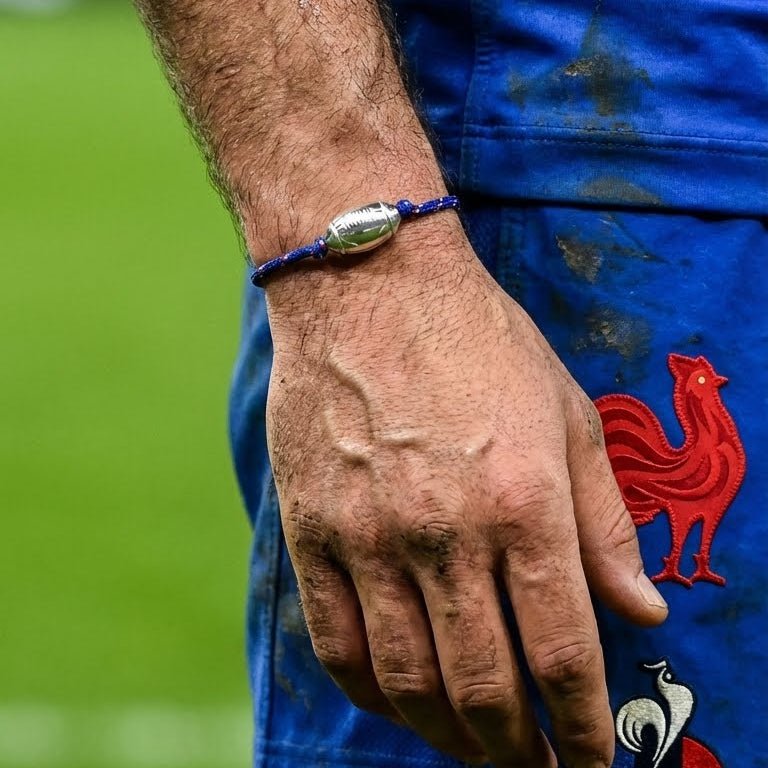 Bracelet cordon bleu marine avec un motif ballon de rugby argenté, style sportif et ajustable.