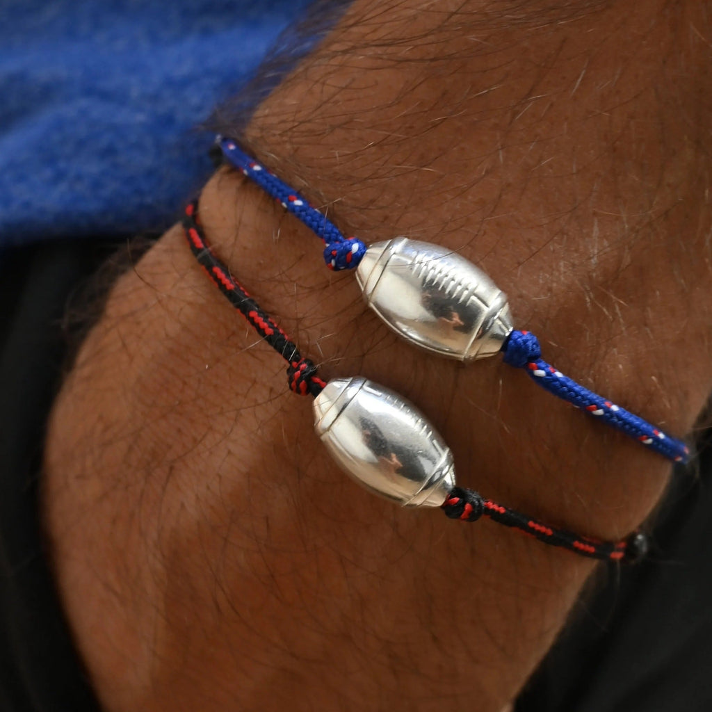 Bracelets cordon bleu et noir avec pendentifs en forme de ballon de rugby argenté, style sportif.