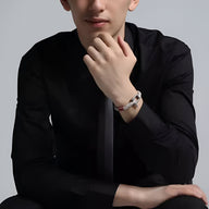 Bracelet cordon blanc avec mousqueton en acier inoxydable, porté au poignet d'un homme en chemise noire.