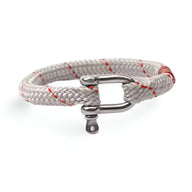 Bracelet cordon blanc avec détails rouges et mousqueton en acier inoxydable argenté.