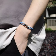 Bracelet cordon bleu et blanc à nœud avec fermoir mousqueton en métal pour homme.