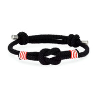 Bracelet cordon noir ajustable avec nœud central et rayures rouges et blanches.