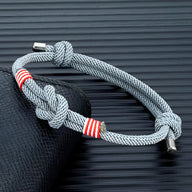 Bracelet cordon gris clair à nœuds avec détails rayés rouges et blancs, ajustable, modèle Kadeo.