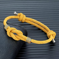 Bracelet cordon jaune à rayures grises, nœud décoratif et fermoirs métalliques, modèle Kadeo.