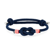 Bracelet cordon bleu marine à nœud central et rayures rouges ajustable avec embouts métalliques.
