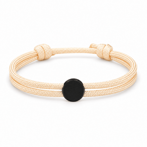Bracelet Marsin Blanc crème et noir, cordon ajustable et pastille ronde, posé de face sur fond blanc