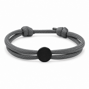 Bracelet Marsin Gris et noir, cordon ajustable et pastille ronde, posé de face sur fond blanc