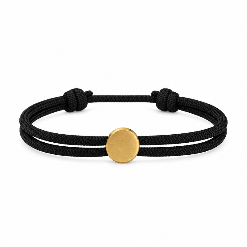 Bracelet Marsin Noir et or, cordon ajustable et pastille ronde, posé de face sur fond blanc