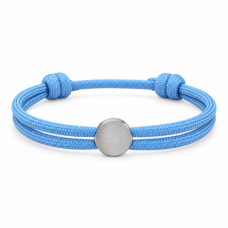 Bracelet Marsin Bleu clair et argent, cordon ajustable et pastille ronde, posé de face sur fond blanc