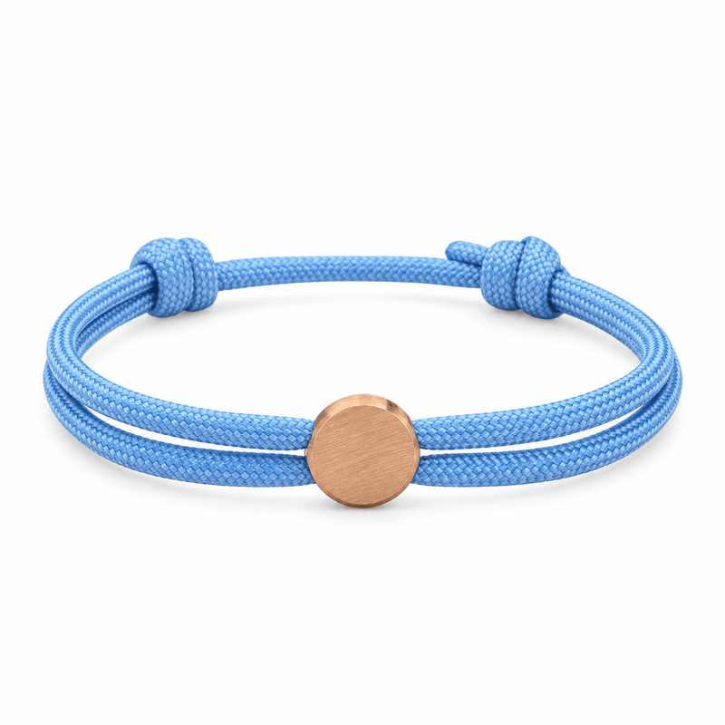 Bracelet Marsin Bleu clair et or rosé, cordon ajustable et pastille ronde, posé de face sur fond blanc
