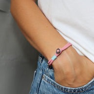 Bracelet cordon rose avec médaillon en argent sterling modèle Vincent porté au poignet.