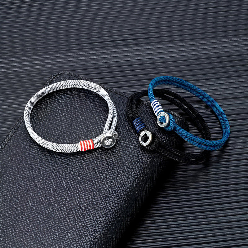 Bracelets cordon bleu marine, noir et gris avec boutons argent sterling et détails rayés rouges et blancs.