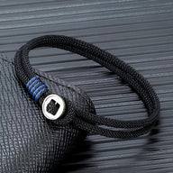 Bracelet cordon noir avec fermoir rond en argent sterling et détails bleus tressés.