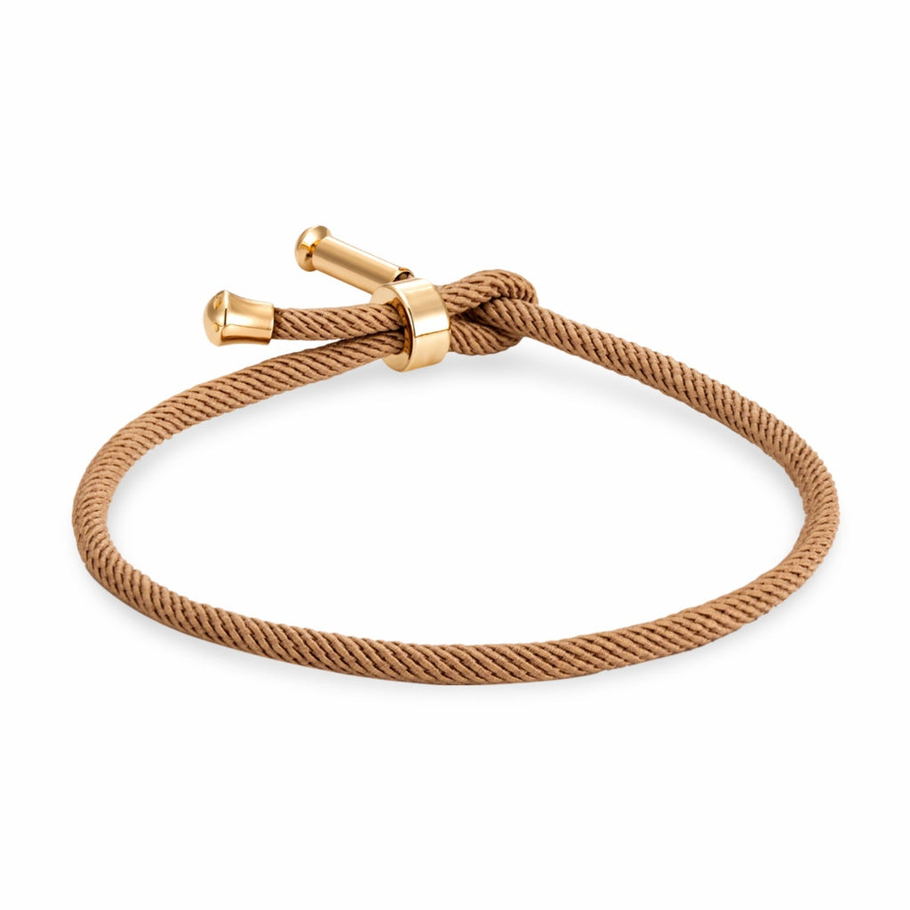 Bracelet cordon beige avec détails en titane plaqué or, fermoir minimaliste noué.