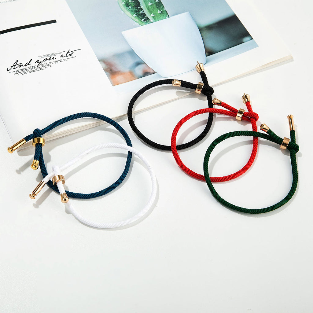 Bracelets cordon rouge, bleu marine, blanc, noir et vert avec détails en titane plaqué or minimalistes.