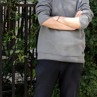 Bracelet cordon rouge fin avec pierre d'agate noire porté au poignet, style minimaliste.