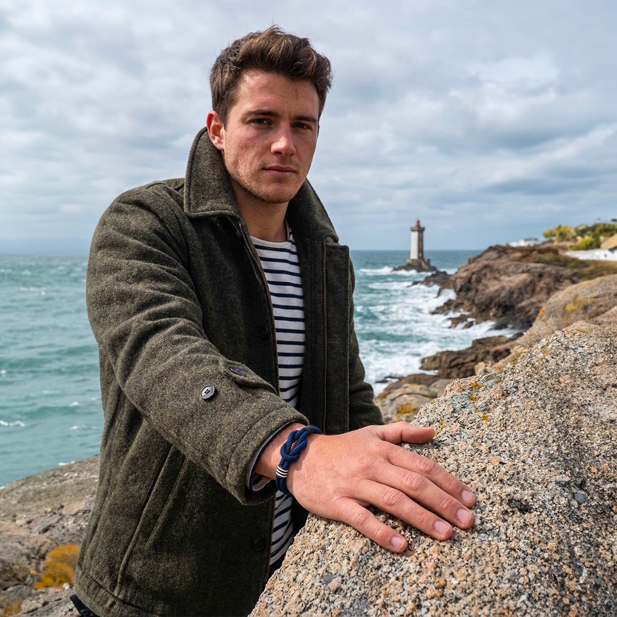 Bracelet en cordon noir et blanc tressé avec noeud marin sur poignet masculin, style breton classique.