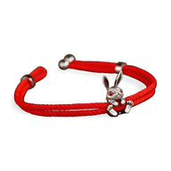 Bracelet cordon rouge avec charm lapin argenté aux yeux rouges et fermoir boule argenté.