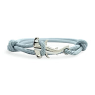 Bracelet cordon bleu clair avec charm en métal argenté en forme de requin marteau.