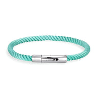 Bracelet cordon turquoise torsadé avec fermoir métallique argenté lisse et moderne.