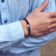 Bracelet cordon bleu marine avec fermoir mousqueton en métal sur poignet homme.