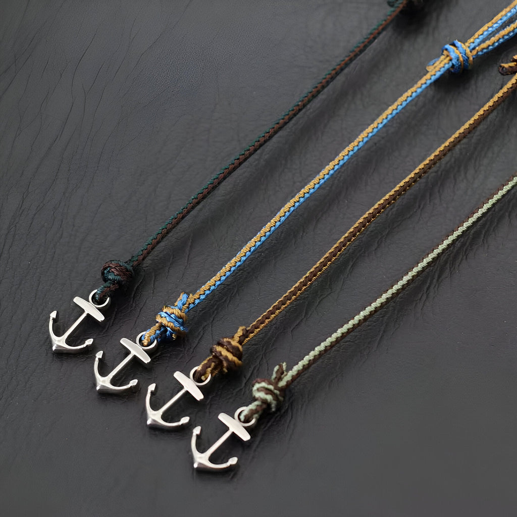 Lot de quatre bracelets cordon coulissant avec ancres marines en métal argenté, en vert foncé, bleu, marron et vert clair.