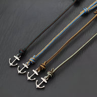 Lot de quatre bracelets cordon coulissant avec ancres marines en métal argenté, en vert foncé, bleu, marron et vert clair.