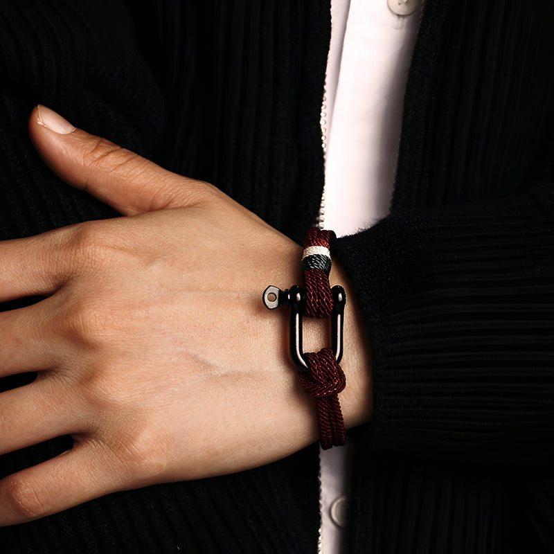 Bracelet cordon rouge avec mousqueton en acier inoxydable porté au poignet homme.