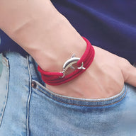 Bracelet cordon rouge pour homme avec pendentif en forme de dauphin argenté.