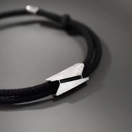 Bracelet cordon noir avec fermoir design épuré en titane, style moderne homme.