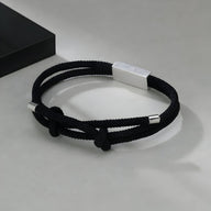 Bracelet cordon noir en titane avec fermoir argenté, design épuré pour homme.
