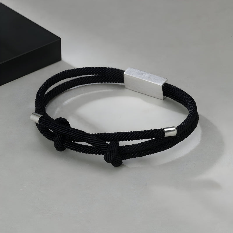 Bracelet cordon noir en titane avec fermoir argenté, design épuré pour homme.
