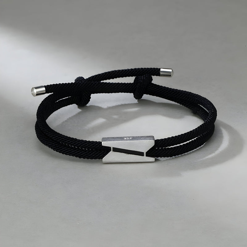 Bracelet cordon noir avec fermoir en titane argenté, design épuré et moderne pour homme.