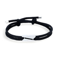 Bracelet cordon noir avec fermoir triangulaire en titane au design épuré pour homme.
