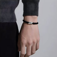 Bracelet cordon noir avec détail en titane, design épuré pour homme, modèle Jones.