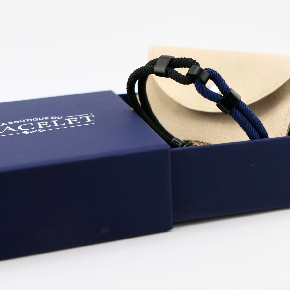 Bracelet cordon double noir et bleu avec nœud coulissant, style décontracté pour homme, présenté dans boîte bleue et étui.