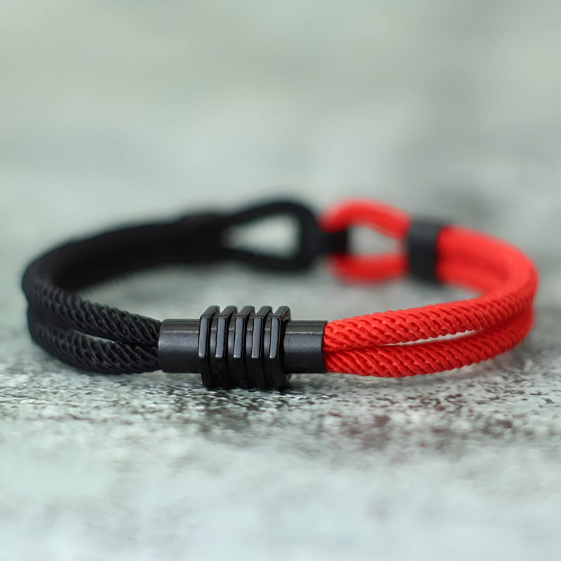 Bracelet cordon double bi-colore rouge et noir avec nœud et détail métallique noir.