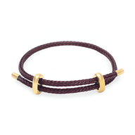 Bracelet cordon marron tressé avec éléments en acier inoxydable doré, style authentique.