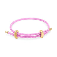 Bracelet cordon rose en acier inoxydable avec anneaux dorés et fermoir minimaliste.