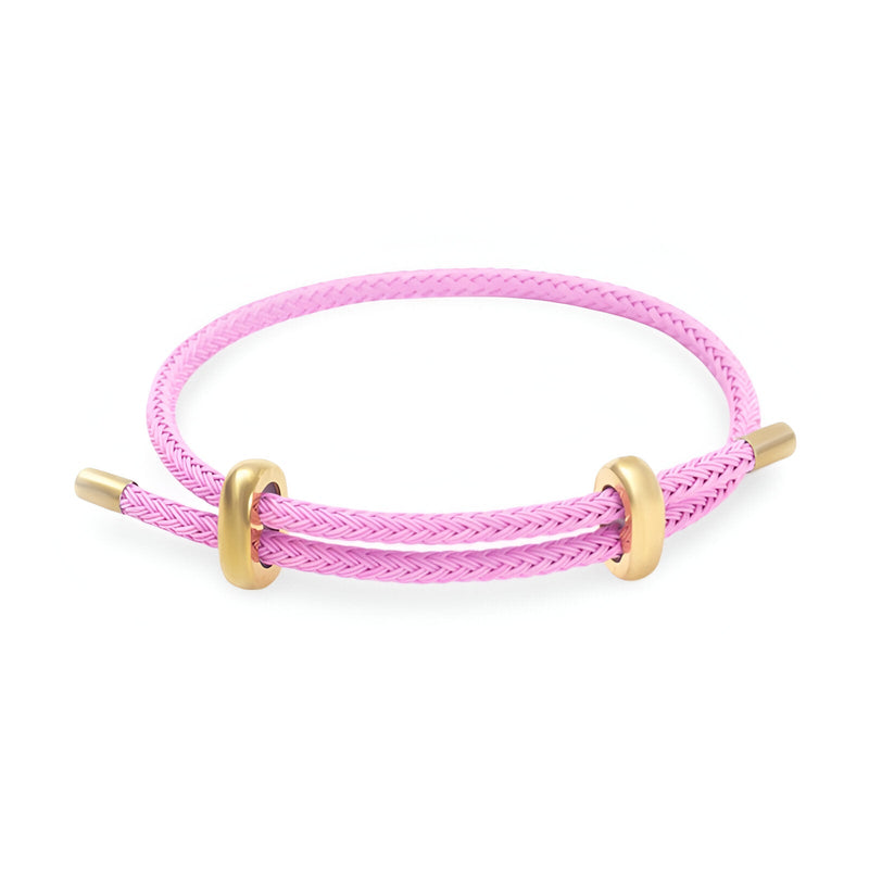 Bracelet cordon rose en acier inoxydable avec anneaux dorés et fermoir minimaliste.