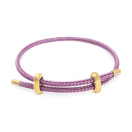 Bracelet cordon violet tressé avec détails en acier inoxydable doré élégant.