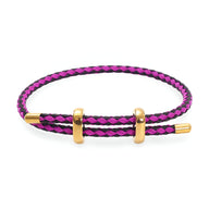 Bracelet cordon tressé rose et noir avec fermoir et anneaux dorés en acier inoxydable.