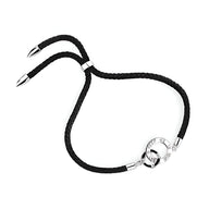 Bracelet cordon noir avec détails en argent sterling et fermoir rond gravé.