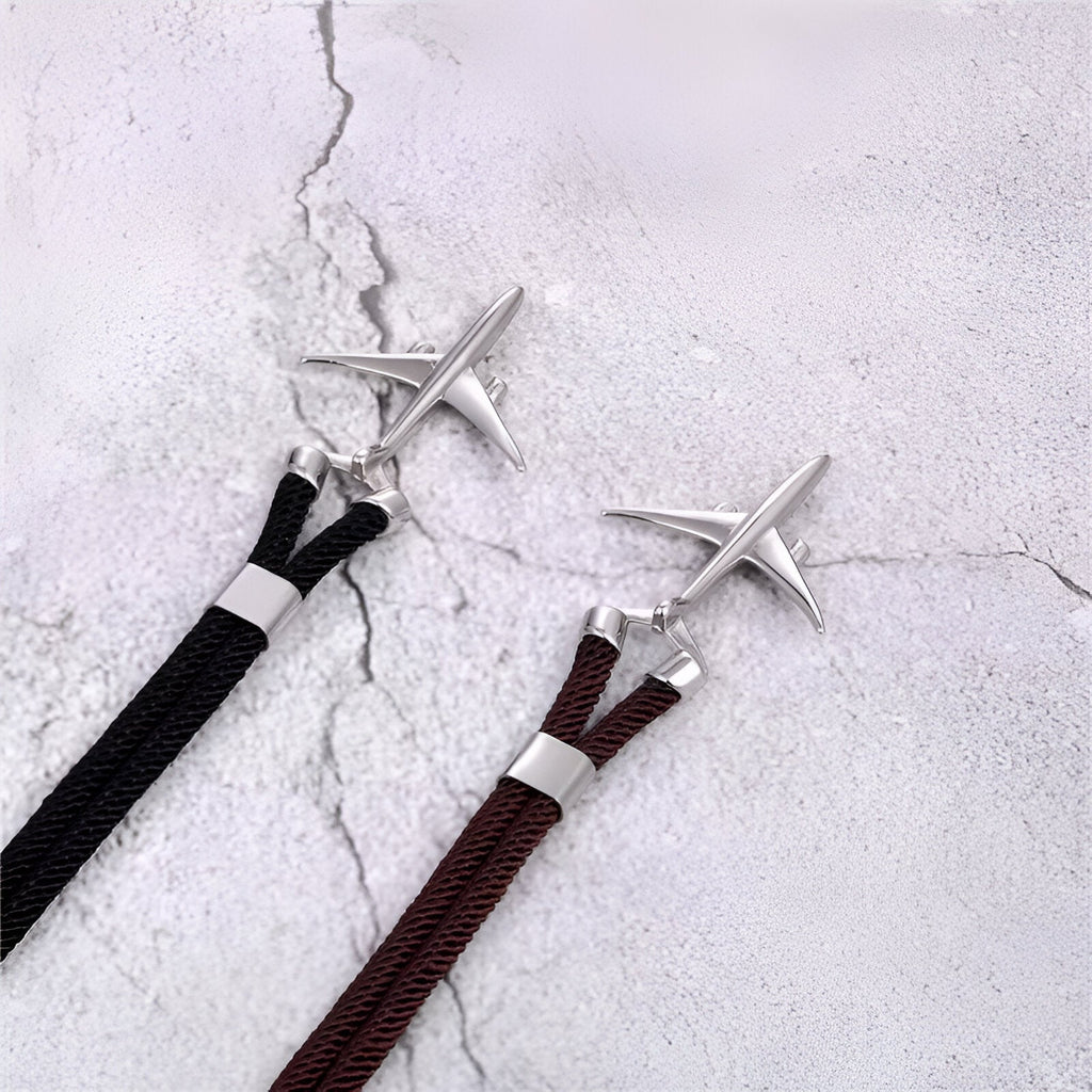 Bracelet cordon noir et bordeaux avec avion en acier inoxydable au design moderne.