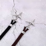 Bracelet cordon noir et bordeaux avec avion en acier inoxydable au design moderne.